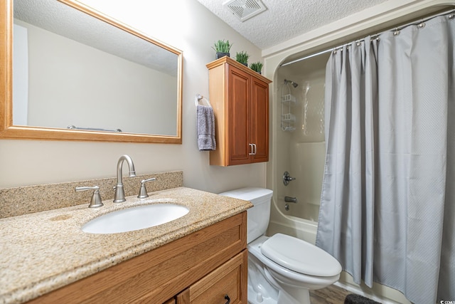 full bathroom with shower / tub combo, vanity, a textured ceiling, and toilet