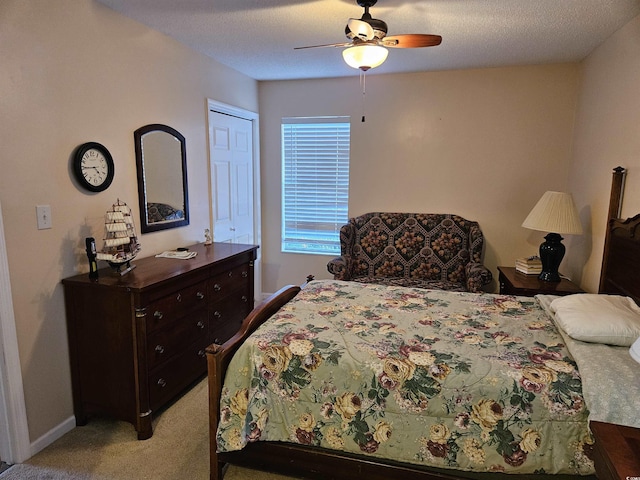 bedroom featuring light carpet, a textured ceiling, a closet, and ceiling fan