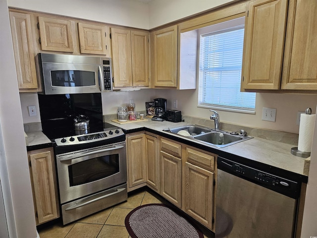 kitchen with light tile patterned floors, sink, and appliances with stainless steel finishes