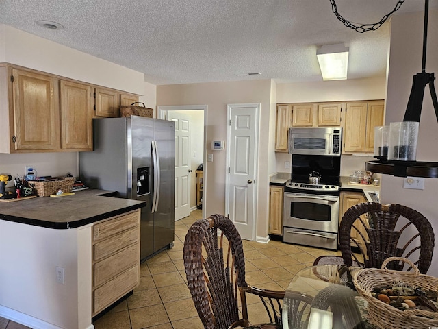 kitchen with a textured ceiling, light tile patterned floors, stainless steel appliances, and light brown cabinetry