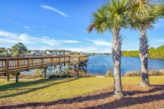 view of dock featuring a water view and a yard