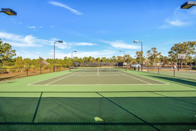 view of tennis court featuring basketball hoop