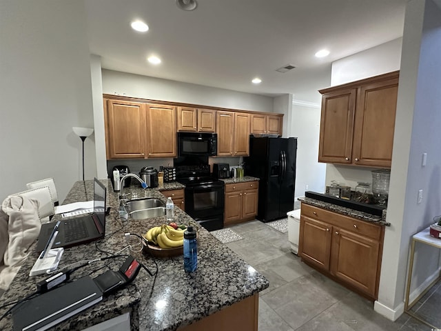 kitchen featuring black appliances, dark stone countertops, and sink