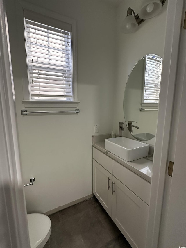 bathroom with tile patterned floors, plenty of natural light, toilet, and vanity