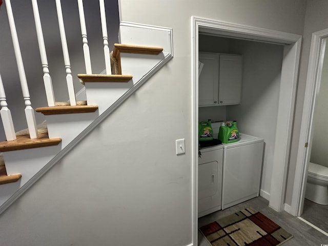 laundry room with washer and clothes dryer, cabinets, and hardwood / wood-style floors