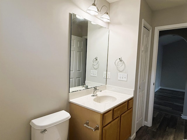 bathroom with hardwood / wood-style flooring, vanity, and toilet