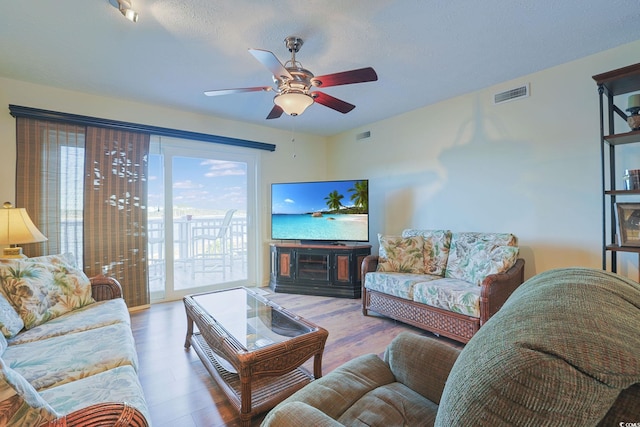 living room featuring hardwood / wood-style floors and ceiling fan