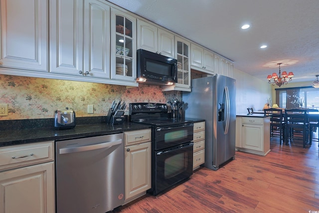 kitchen featuring black appliances, dark hardwood / wood-style floors, backsplash, and a chandelier