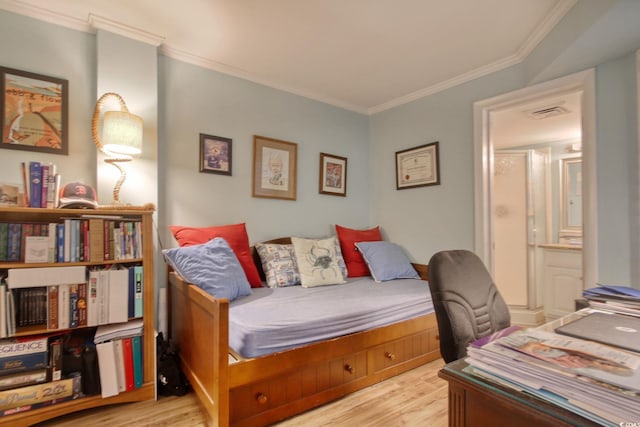 bedroom featuring ornamental molding and light hardwood / wood-style flooring