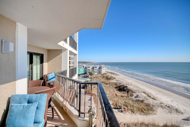 balcony featuring a water view and a view of the beach