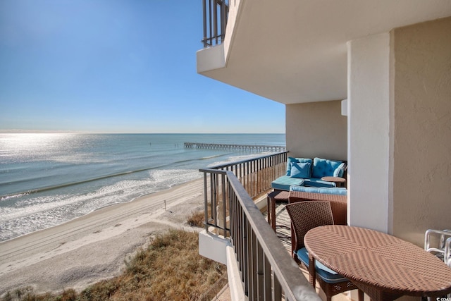 balcony featuring a water view and a view of the beach