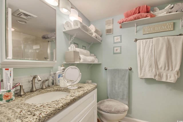 bathroom with decorative backsplash, vanity, toilet, and walk in shower