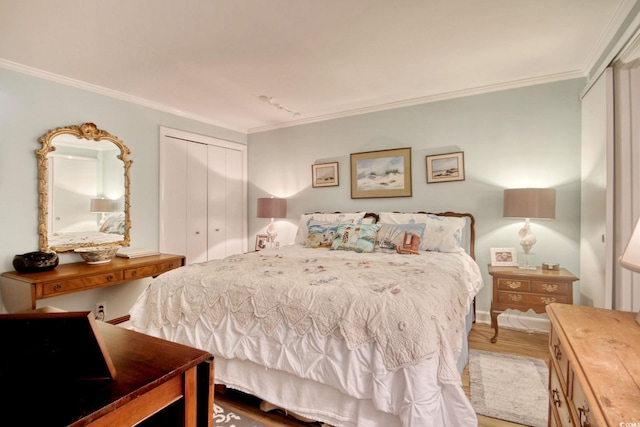 bedroom with hardwood / wood-style flooring, crown molding, and a closet