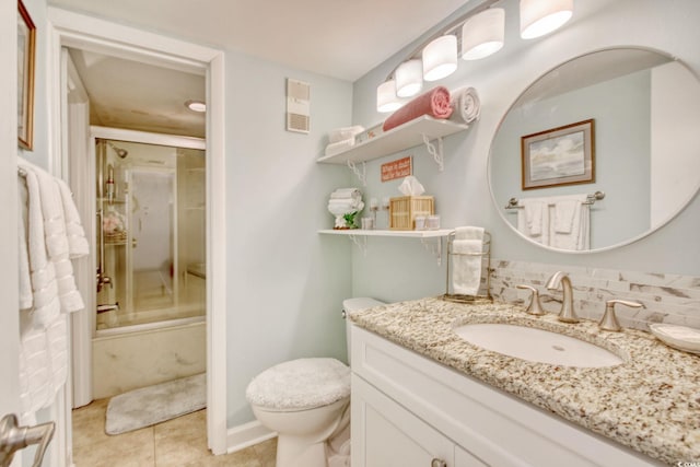 full bathroom featuring vanity, combined bath / shower with glass door, tile patterned flooring, decorative backsplash, and toilet