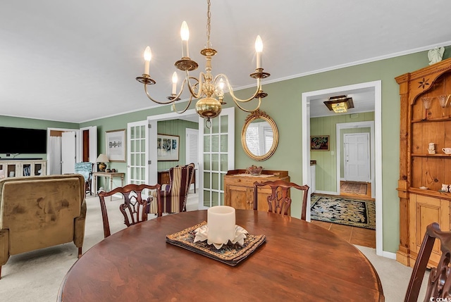 carpeted dining room featuring french doors, ornamental molding, and a notable chandelier