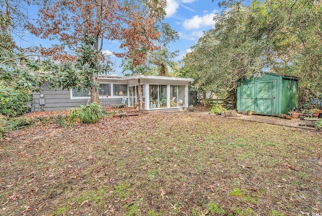 back of property featuring a sunroom and a shed