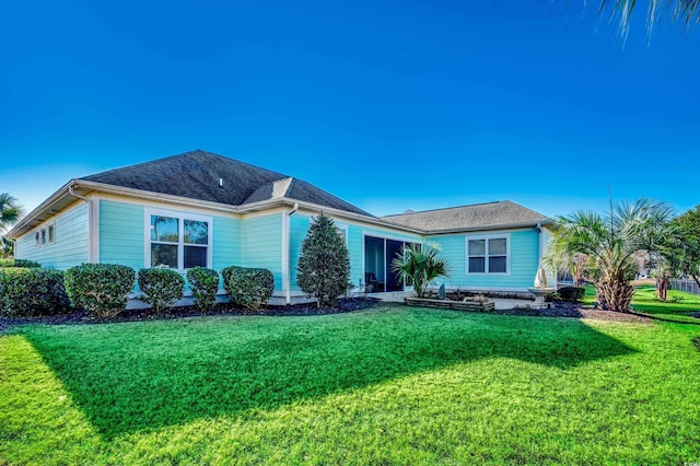 rear view of property featuring a lawn