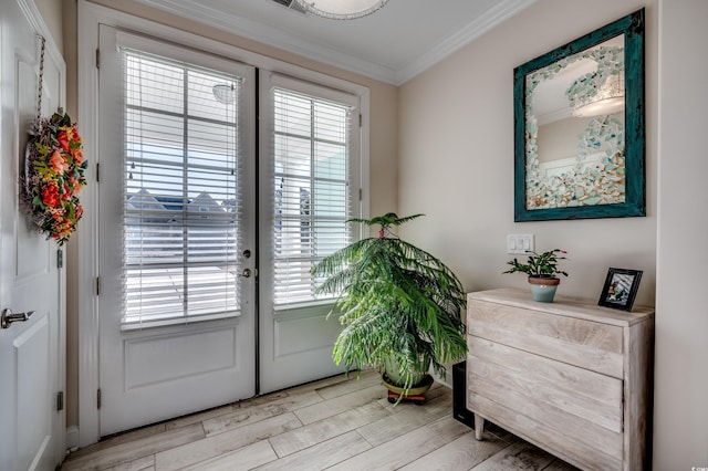 doorway to outside featuring a healthy amount of sunlight, french doors, ornamental molding, and light hardwood / wood-style flooring