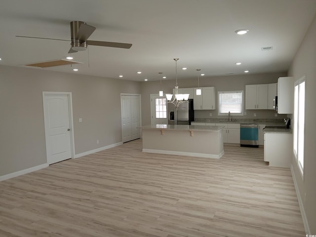 kitchen featuring a kitchen island, appliances with stainless steel finishes, white cabinetry, a sink, and recessed lighting