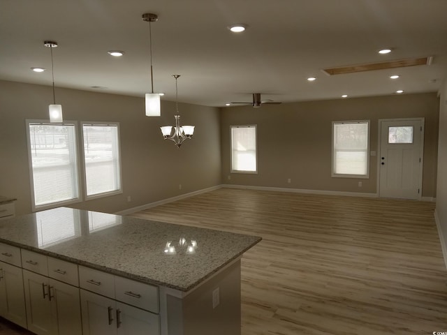 kitchen with recessed lighting, baseboards, white cabinets, light wood-type flooring, and decorative light fixtures