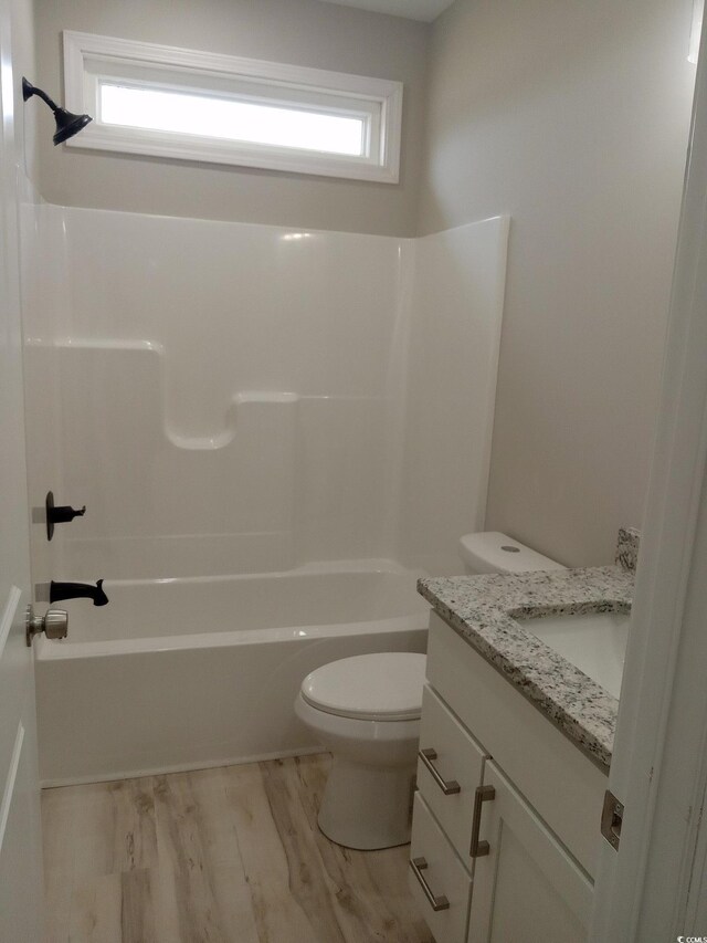 bathroom featuring tub / shower combination, vanity, toilet, and wood finished floors