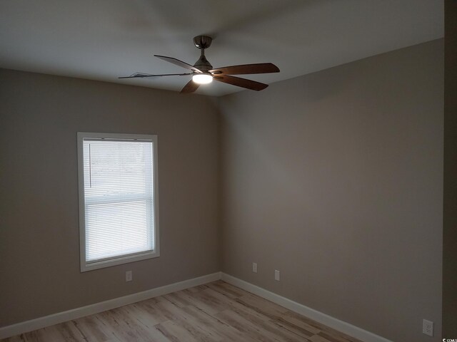 unfurnished room with ceiling fan, light wood finished floors, and baseboards