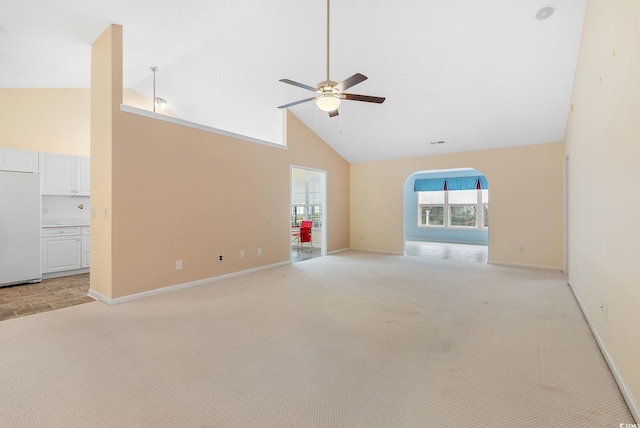 unfurnished living room with ceiling fan, light colored carpet, and high vaulted ceiling