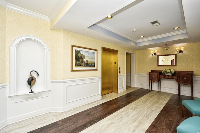 interior space featuring crown molding, elevator, and a tray ceiling