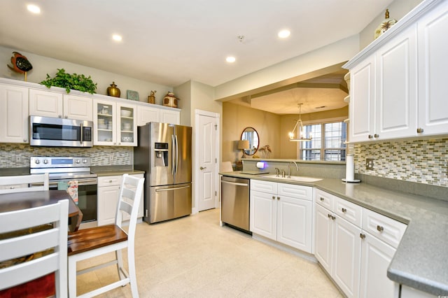 kitchen with pendant lighting, white cabinets, and stainless steel appliances