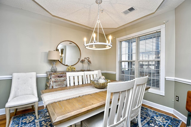 dining room featuring a chandelier, a textured ceiling, and hardwood / wood-style flooring