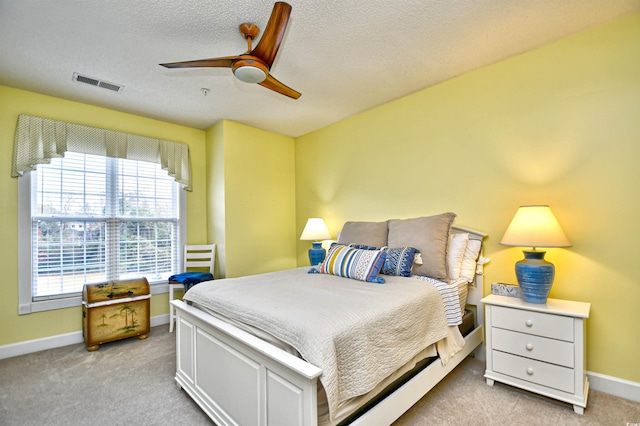 bedroom with light carpet, a textured ceiling, and ceiling fan