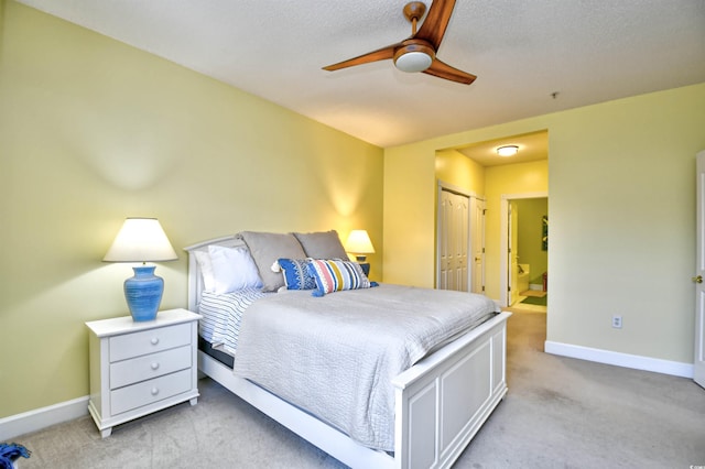 carpeted bedroom with ceiling fan, ensuite bathroom, and a closet