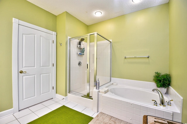 bathroom with separate shower and tub, tile patterned floors, and a textured ceiling