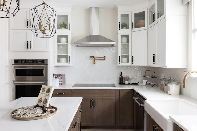 8411 Flamingo Ct Unit 7, Myrtle Beach, SC 29572 - kitchen featuring wall chimney exhaust hood, appliances with stainless steel finishes, a chandelier, dark brown cabinetry, and hanging light fixtures