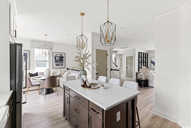 8411 Flamingo Ct Unit 7, Myrtle Beach, SC 29572 - kitchen featuring a kitchen breakfast bar, open floor plan, a chandelier, freestanding refrigerator, and dark brown cabinets