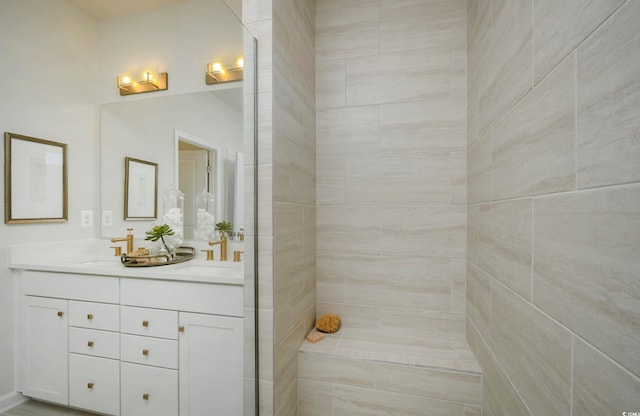 bathroom with tiled shower and vanity