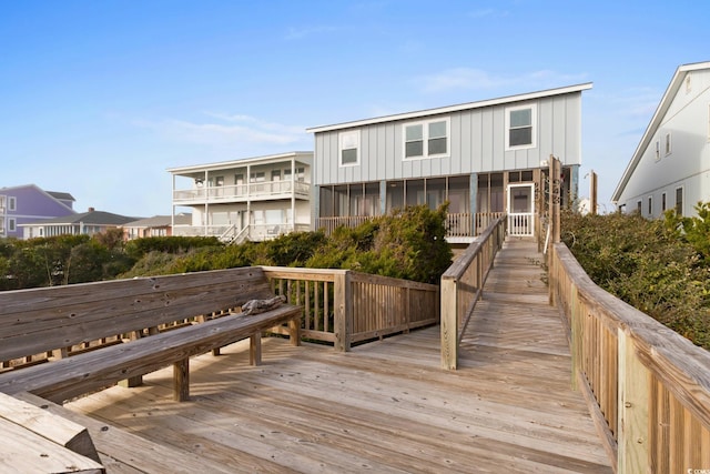 back of property featuring a wooden deck and a sunroom