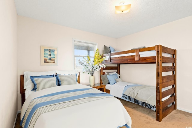 bedroom featuring light colored carpet and a textured ceiling