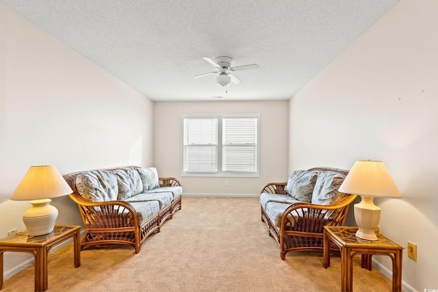 living area with light carpet, ceiling fan, and a textured ceiling