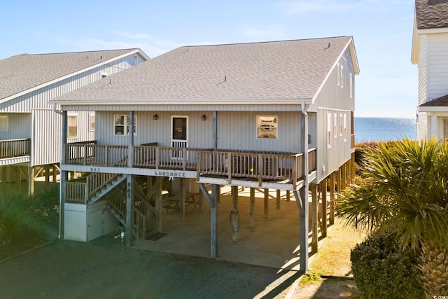 rear view of house featuring a carport and a water view