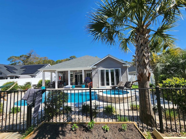 view of pool featuring a pool with connected hot tub, a patio area, fence, an outdoor structure, and a storage structure