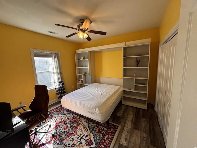 bedroom featuring dark wood-style floors, visible vents, and a ceiling fan