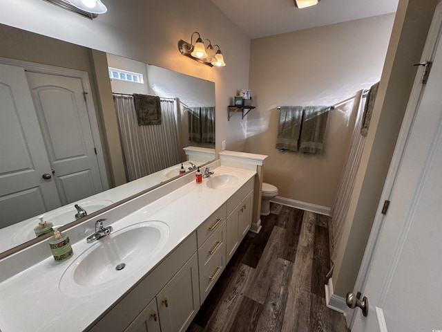 full bathroom featuring double vanity, a sink, and wood finished floors