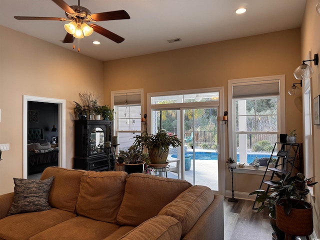 living area featuring baseboards, wood finished floors, visible vents, and recessed lighting