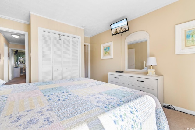 bedroom featuring carpet flooring, crown molding, and a closet