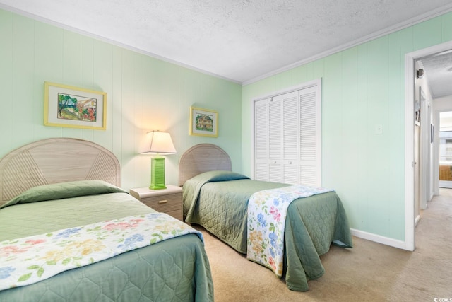 bedroom featuring a textured ceiling, light colored carpet, a closet, and ornamental molding