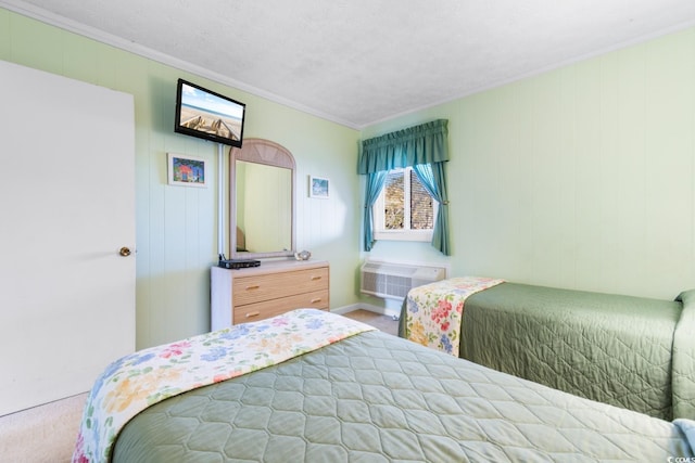 carpeted bedroom featuring a wall unit AC, crown molding, and a textured ceiling