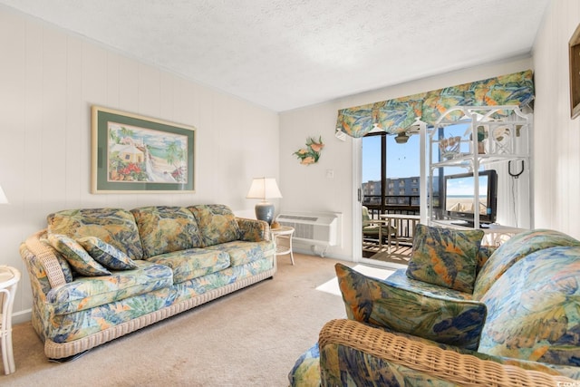 living room featuring a wall mounted AC, carpet floors, and a textured ceiling