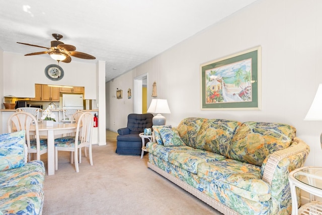 carpeted living room with ceiling fan