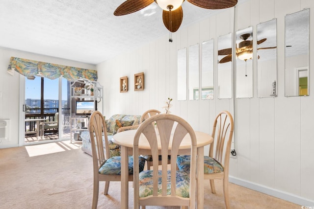 carpeted dining room featuring wooden walls and a textured ceiling